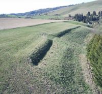 Čierny Balog – 338 m2 POĽNOHOSPODÁRSKY pozemok v 1/1 - Zelené poľnohospodárske a lesné pozemky v Čiernom Balogu s kopcovitou krajinou a stromami.