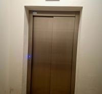 Priestranná garzónka s balkónom v novostavbe. - Kovové dvere výťahu s displejom v garsónke.