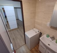 Krásny 3 izbový byt na prenájom. - Kúpeľňa so zrkadlom a práčkou v 3-izbovom byte s podlahou s dreveným dekorom.