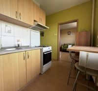 Predaj pekný 1 izbový byt, 35 m2, Dudvážska ulica, BA II. - Kuchyňa v 1-izbovom byte s podlahou s dreveným dekorom, jedálenský stôl a vybavenie.