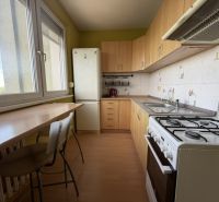 Predaj pekný 1 izbový byt, 35 m2, Dudvážska ulica, BA II. - Kuchyňa v 1-izbovom byte s podlahou s dreveným dekorom a svetlým nábytkom.