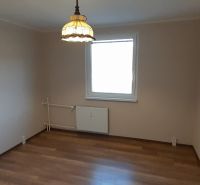 Pekný 2 izbový byt s balkónom na prenájom. - Izba v 2-izbovom byte s podlahou s dreveným dekorom a svetlom nad radiátorom.