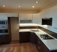 Pekný 2 izbový byt s balkónom na prenájom. - Kuchyňa v 2-izbovom byte s podlahou s dreveným dekorom a zabudovanými spotrebičmi.