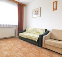 STRÁNE - 5 izbový rodinný dom na predaj - Obývacia izba s pohovkou, kreslom, obrazmi na stene, podlaha s dreveným dekorom.