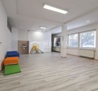 Komerčný priestor v centre mesta - Interiér obchodných priestorov s podlahou s dreveným dekorom, svetlé steny a veľké okná.