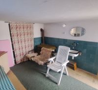 RODINNÝ DOM, pozemok 290m2,  MEDZIBROD okr. Banská Bystrica   - Izba v rodinnom dome s umývadlom, zrkadlom a plastovým kreslom.