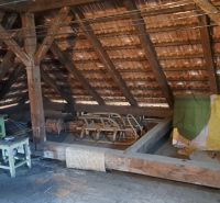 RODINNÝ DOM, pozemok 290m2,  MEDZIBROD okr. Banská Bystrica   - Podkrovie rodinného domu s drevenými trámami a jednoduchým nábytkom.