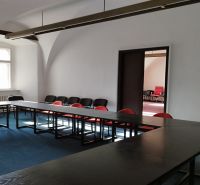 PRENÁJOM: Kancelárie 2x 50m2, Kapitulská ul.Banská Bystrica - Žena v kancelárii s plochým stolom, stoličkami a oblúkovou architektúrou v Banskej Bystrici.