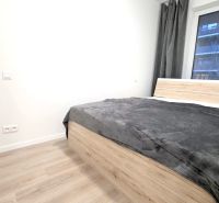 U NÁS !!! MODERNÝ 2i,NOVOSTAVBA, LOGGIA, Slnečnice UNIQ, Fialova ulica - Spálňa s posteľou a podlahou s dreveným dekorom v 2-izbovom byte.