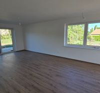 Bungalov v centre obce Cabaj v štandarde, Wágnerova ulica, Dom č.2 - Miestnosť s veľkými oknami a podlahou s dreveným dekorom v rodinnom dome.