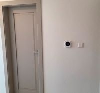 Bungalov v centre obce Cabaj v štandarde, Wágnerova ulica, Dom č.2 - Dvere v rodinnom dome s podlahou s dreveným dekorom a bielou stenou.