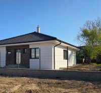 Bungalov v centre obce Cabaj v štandarde, Wágnerova ulica, Dom č.2 - Rodinný dom v Cabaji-Čápore s bielou fasádou a šikmou strechou obklopený plotom.