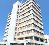 FORVIN TOWER - Predaj administratívnej budovy, Veľký Krtíš - Výšková budova Liaz s autami zaparkovanými na ulici, zvlášť zaujímavá nehnuteľnosť.