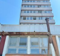 FORVIN TOWER - Predaj administratívnej budovy, Veľký Krtíš - Budova na ulici Liaz so zvláštnou nehnuteľnosťou, poschodia, okná, modrá obloha.