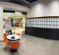 Prenájom obchodného priestoru - Kamenné pole, LM - Interiér obchodných priestorov s recepciou, stoličkami a lístiami na stene.
