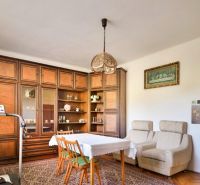 PREDAJ - Rodinný dom s priestranným pozemkom 2266 m² - Veľký Kýr - Obývacia izba s podlahou s dreveným dekorom v rodinnom dome, útulné kreslá a skriňová zostava.