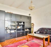 PREDAJ - Rodinný dom s priestranným pozemkom 2266 m² - Veľký Kýr - Obývačka v Rodinnom dome s kobercami, skriňami a pohovkou, podlaha s dreveným dekorom.