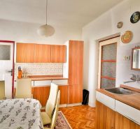 PREDAJ - Rodinný dom s priestranným pozemkom 2266 m² - Veľký Kýr - Kuchyňa v rodinnom dome s podlahou s dreveným dekorom a jedálenským stolom.