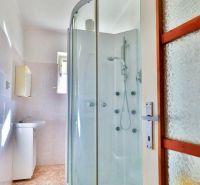 PREDAJ - Rodinný dom s priestranným pozemkom 2266 m² - Veľký Kýr - Kúpeľňa v rodinnom dome s rohovou sprchou a umývadlom, podlaha s dekorom dlaždíc.
