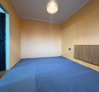Na predaj: CENTRUM 3 izb.byt + LOGGIA + KLÍMA + PIVNICA - Izba s modrým kobercom a oranžovými stenami v 3-izbovom byte.