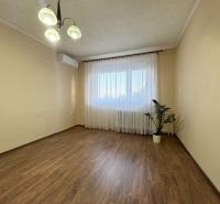 Na predaj: CENTRUM 3 izb.byt + LOGGIA + KLÍMA + PIVNICA - Obývačka v 3-izbovom byte s podlahou s dreveným dekorom a svetlým interiérom.