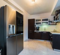 NA PREDAJ Luxusný 3-izbový byt v centre mesta Nitra - Kuchyňa v 3-izbovom byte s tmavými skrinkami a modernými spotrebičmi.