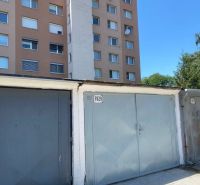 PREDAJ - Garáž v Stupave na ulici Železničná - Garáže na Železničnej ulici v Stupave, s bytovým domom v pozadí.