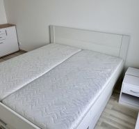 4 izbový byt 150 m2 novostavba Petržalka v Slnečniciach  s terasou, 2x - Spálňa v 4-izbovom byte s posteľou, skrinkou a podlahou s dreveným dekorom.