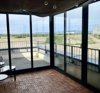 4 izbový byt 150 m2 novostavba Petržalka v Slnečniciach  s terasou, 2x - Zasklená terasa s podlahou s dreveným dekorom v 4-izbovom byte, s výhľadom na panorámu.