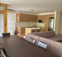 4 izbový byt 120 m2 Ružová dolina, Ružinov, 1x podzemné´parkovanie - Otvorená kuchyňa v 4-izbovom byte s jedálenským stolom a pohovkou.