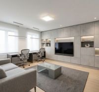 PREDAJ NADŠTANDARDNÝ 7-IZBOVÝ RODINNÝ DOM, WELLNESS, ZÁHRADA - Obývacia izba v rodinnom dome so sivou sedačkou, TV stenou a podlahou s dreveným dekorom.