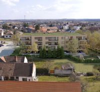 Developerský projekt SRDCE GROBU! - Budova obklopená zeleňou v zastavanej časti mesta, s výhľadom na susedné domy.