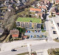 Developerský projekt SRDCE GROBU! - Letecký pohľad na bytový dom s parkoviskom a zelenou strechou v obytnej zóne.