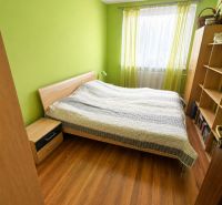 3 izbový byt 75m2, ul.Bruselská, Košice- Ťahanovce - Spálňa v 3-izbovom byte so zelenými stenami a podlahou s dreveným dekorom.