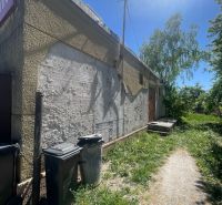 Postavte si dom alebo podnikajte - Exteriér budovy v Ondrejovciach s trávnatým okolím a odpadkovými košmi.