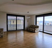 Na prenájom nadštandardný 2-izbový byt - 65 m² v centre Vranova nad To - Obývačka 2-izbového bytu s podlahou s dreveným dekorom a veľkými oknami.
