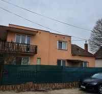 Dom na bývanie a podnikanie na 15 ár. pozemku 35 km od BA - Rodinný dom v Orechovej Potôni s oranžovou fasádou, balkónom a autom pred ním.