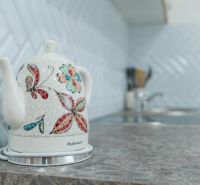 Moderný apartmán v centre Rajeckých Teplíc rovno oproti kúpeľom Afrodi - Keramická kanvica s farebným vzorom na kuchynskej linke Rekreačného apartmánu.