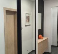 Nadštandardný, dômyselne zariadený 3-izbový byt  - PREDAJ. - Predsieň so zrkadlovou skriňou v 3-izbovom byte, podlaha s dreveným dekorom.