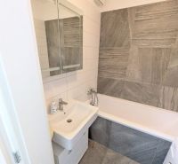 Moderný 2-izbový byt s balkónom a výhľadom - Kúpeľňa v 2-izbovom byte s umývadlom, vaňou a svetlými obkladmi.