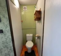 Na predaj : Slnečný 3-izbový byt – sídlisko Rozkvet - Toaleta so zelenými stenami a bielou sanitou v 3-izbovom byte.
