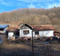 Na predaj chalupa Banská Hodruša v tichej lokalite - Starší rodinný dom na ulici Banská Hodruša, okolie tvorí les a plot.