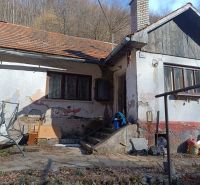 Na predaj chalupa  Banská Hodruša v tichej lokalite - Na obrázku je starší rodinný dom na ulici Banská Hodruša s vyrastenou trávou.