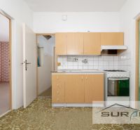 PREDAJ | 4-izbový byt s loggiou | Bullova ulica | Bratislava - Kuchyňa so staršími skrinkami a spotrebičmi v 4-izbovom byte s tapetami.