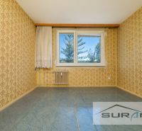 PREDAJ | 4-izbový byt s loggiou | Bullova ulica | Bratislava - Izba s textúrovanými tapetami, modrou podlahou a oknom v 4-izbovom byte.