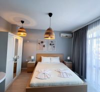Moderná garsónka (41 m²) s výhľadom na bazén – Rezort ANTARES - Garsónka s manželskou posteľou, skriňou a nočnými stolíkmi, dekor dreveného nábytku.