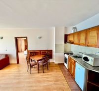 3-izbový apartmán v prvej línii pri mori s Aktom 16 - Otvorená kuchyňa s jedálenským stolom a podlahou s dreveným dekorom v 3-izbovom byte.