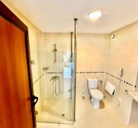 3-izbový apartmán v prvej línii pri mori s Aktom 16 - Kúpeľňa v 3-izbovom byte s toaletou a sprchovým kútom, svetlé obklady.