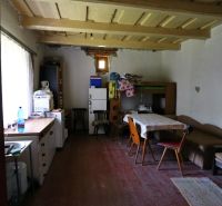 DOM IDEÁLNY PRE ĽUDÍ ČO HĽADAJÚ SAMOTU, POKOJ A PRÍRODU - Izba v rodinnom dome s jedálenským stolom a pohovkou, podlaha s dreveným dekorom.