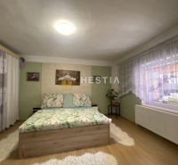 NA PREDAJ 6-IZB. RODINNÝ DOM, Senica – Čáčov - Spálňa v rodinnom dome s podlahou s dreveným dekorom a vzorovanou posteľou.